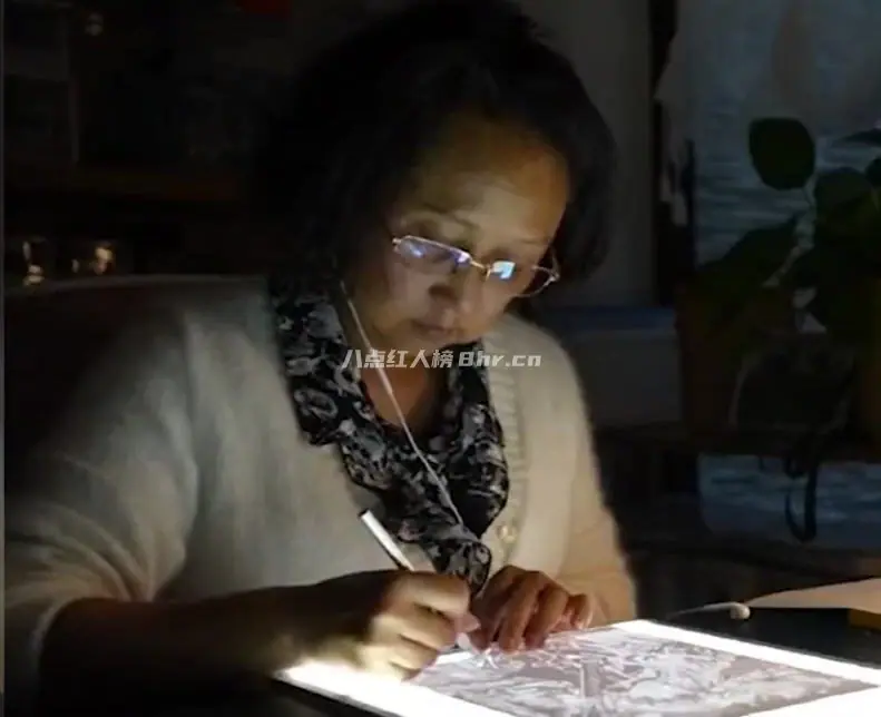 用刀在纸上作画的阿姨